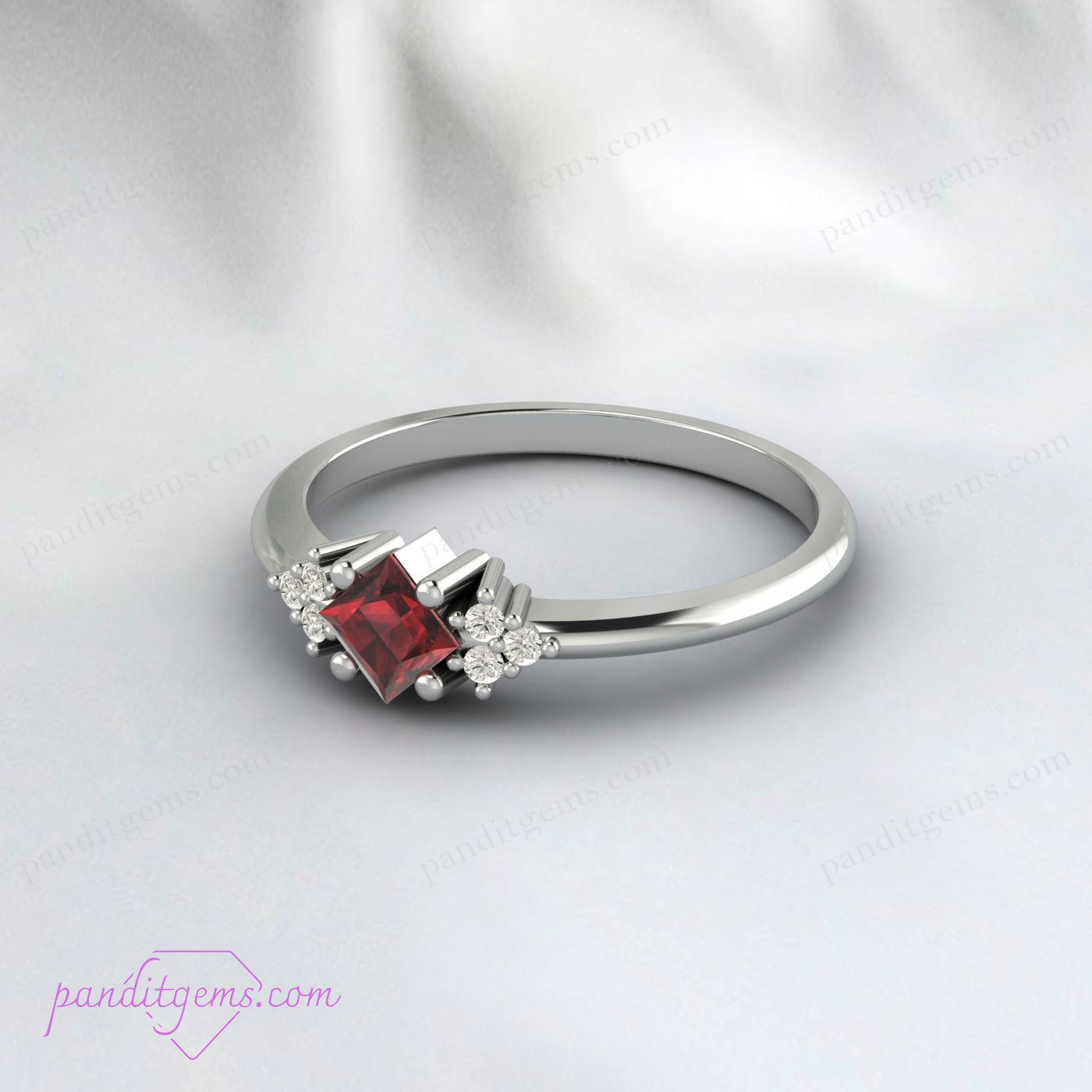 Red garnet and diamond-accented silver ring, perfect for anniversaries or weddings.