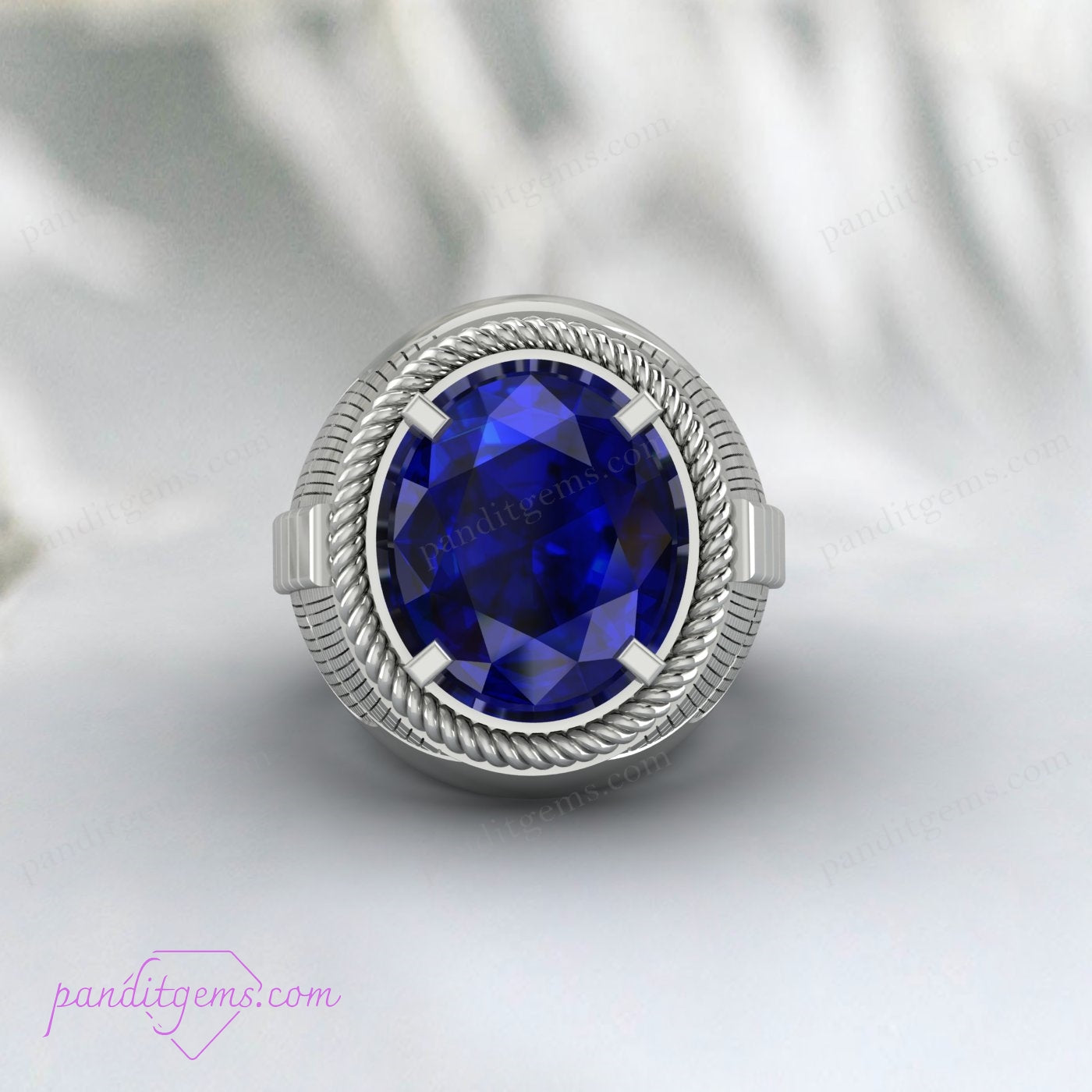 Shiny silver men’s jewelry featuring an oval-cut blue sapphire in a Greek-inspired design.
