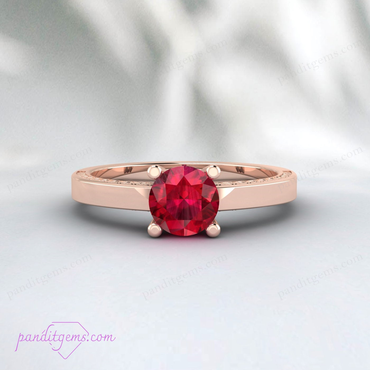 Antique red ruby solitaire ring with intricate engraving.