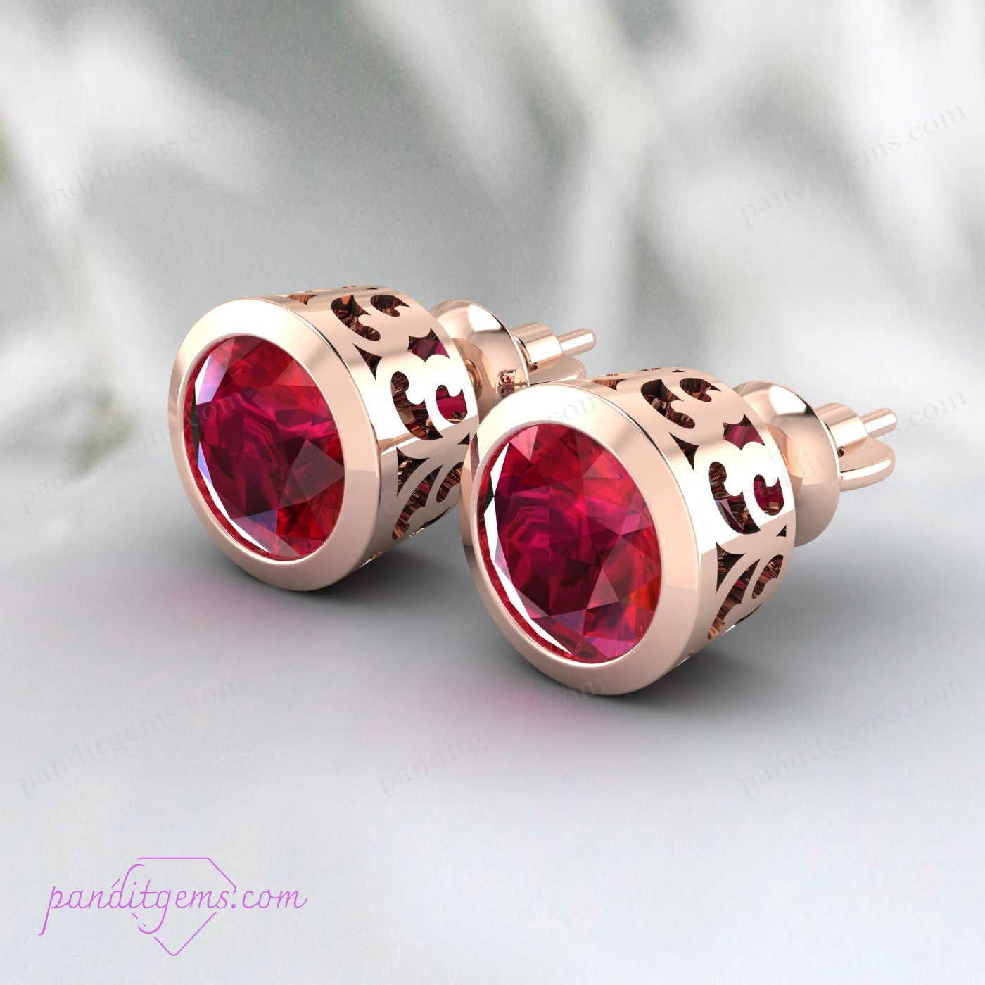 Bezel set ruby earrings in sterling silver, showcasing a brilliant-cut round ruby.