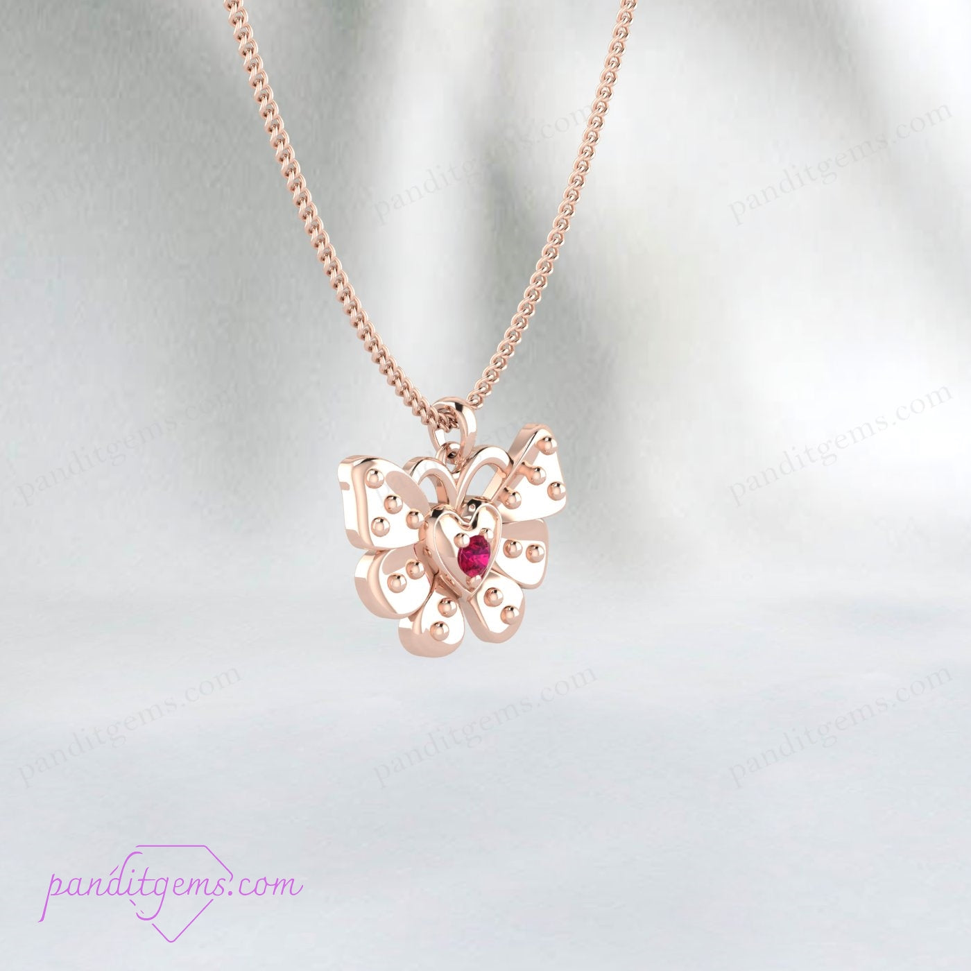 Close-up of a ruby butterfly pendant necklace on a white background.