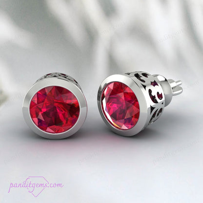 Close-up of filigree design on ruby stud earrings in solid gold.