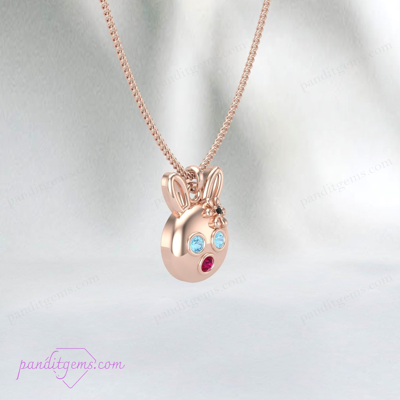 Cute rabbit charm necklace with Aquamarine, Ruby, and Onyx stones, handcrafted in sterling silver with gold accents.