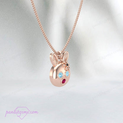 Cute rabbit charm necklace with Aquamarine, Ruby, and Onyx stones, handcrafted in sterling silver with gold accents.
