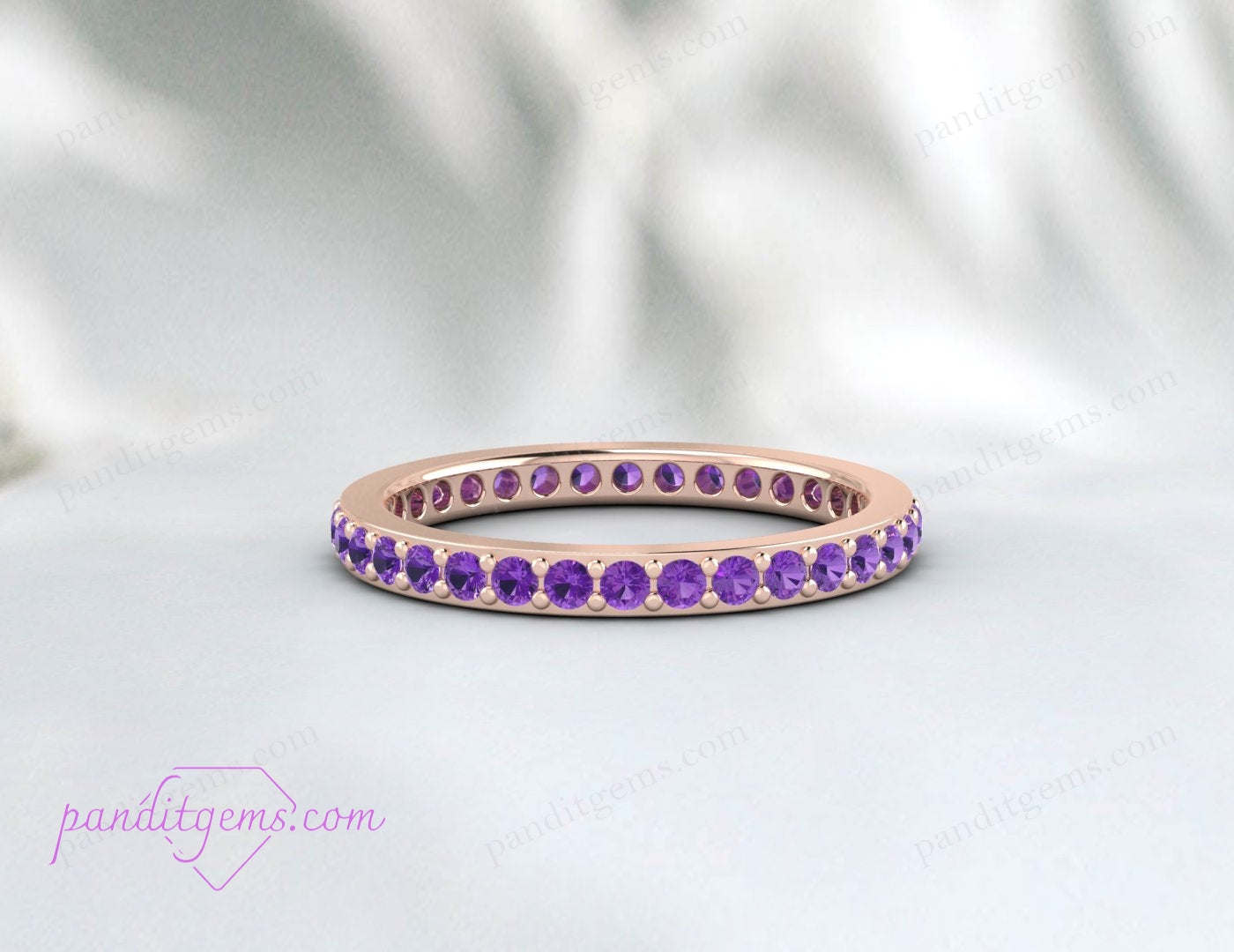 Dainty amethyst eternity wedding band in 14k rose gold, designed for stacking. The 2mm round stones symbolize eternal love and commitment.