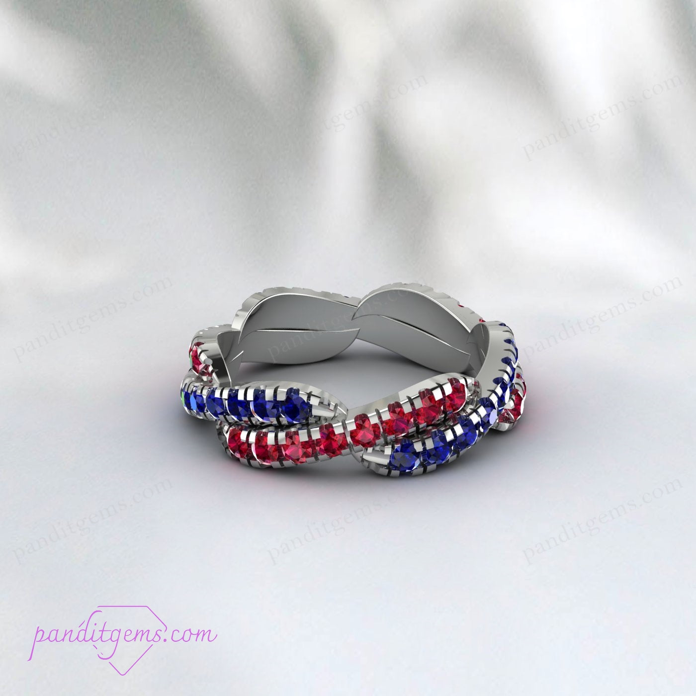 Detailed view of Blue Sapphire and Ruby gemstones set in a twisted infinity band made of 925 sterling silver.