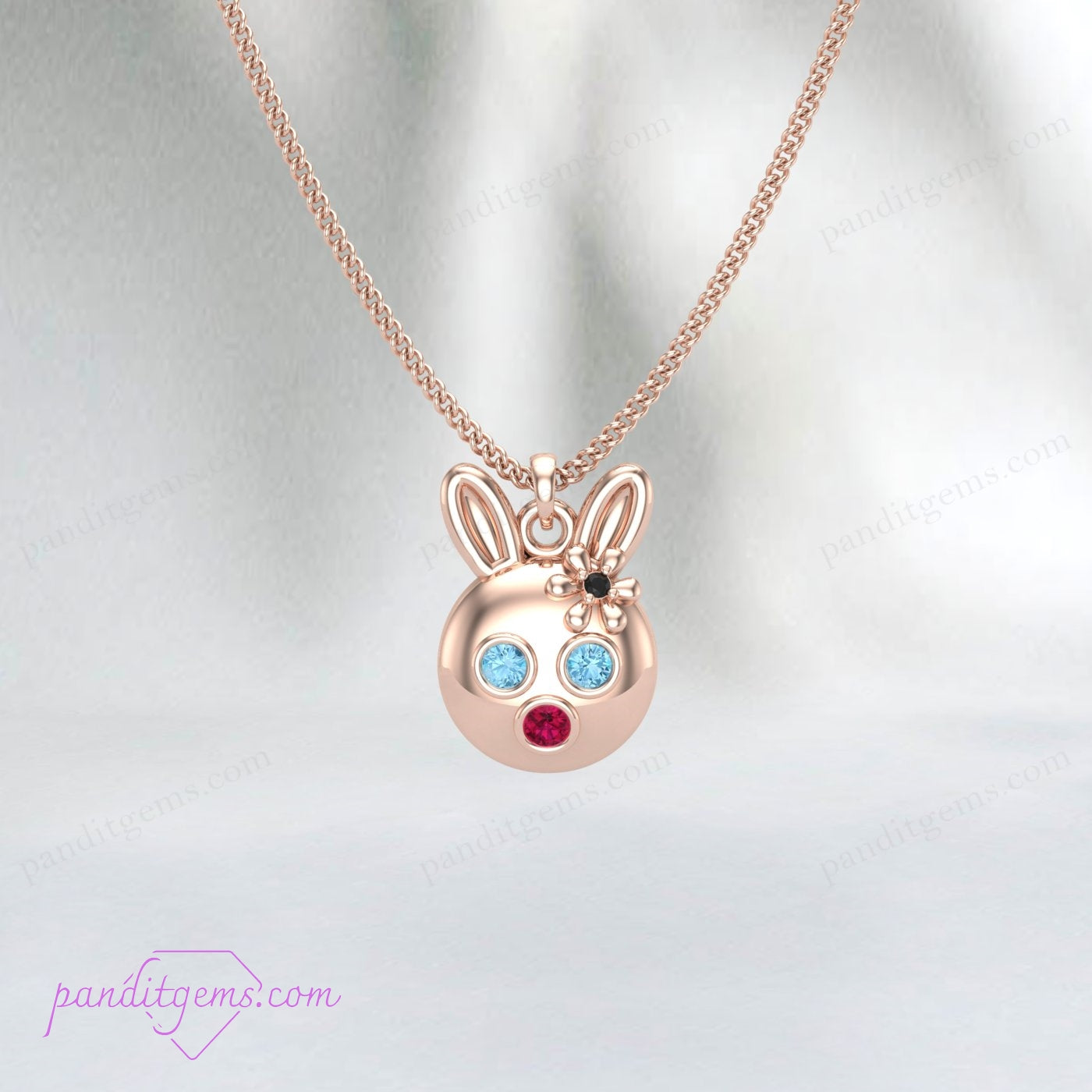 Handcrafted sterling silver bunny pendant adorned with Aquamarine, Ruby, and Onyx gemstones on a delicate chain.