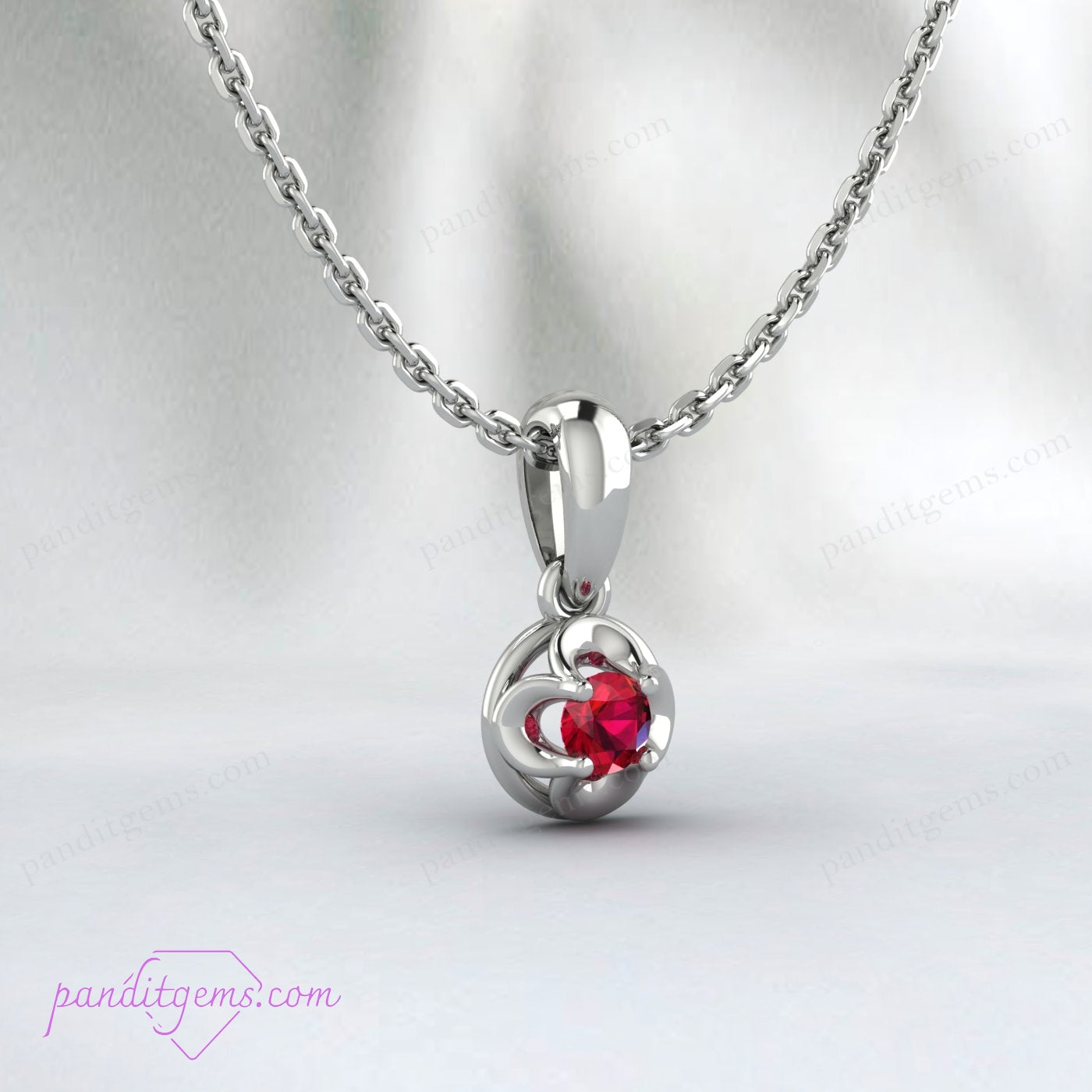 A delicate gold necklace featuring the July birthstone, ruby, in a solitaire setting.