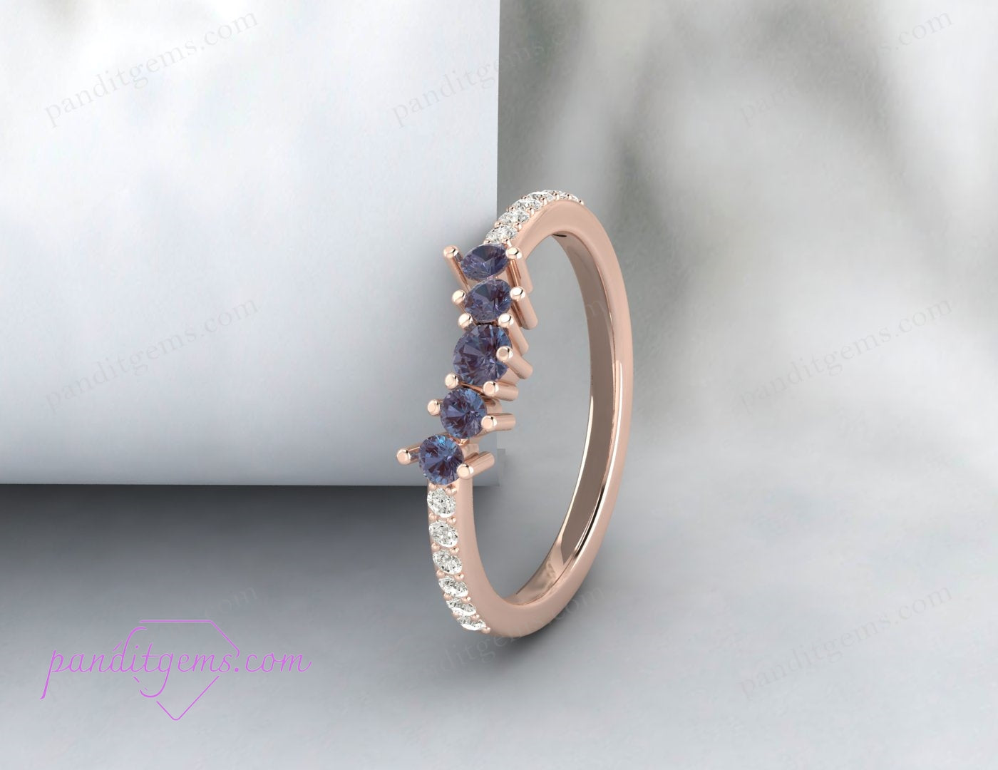 A rose gold-plated wedding ring with a curved design and Alexandrite center stone.