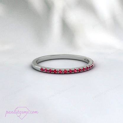 A hand wearing the ruby wedding band in white gold.