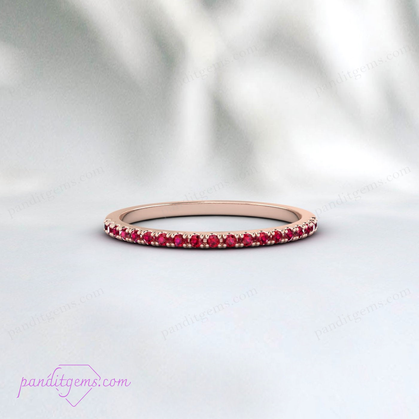 The ruby wedding band worn alongside an engagement ring.