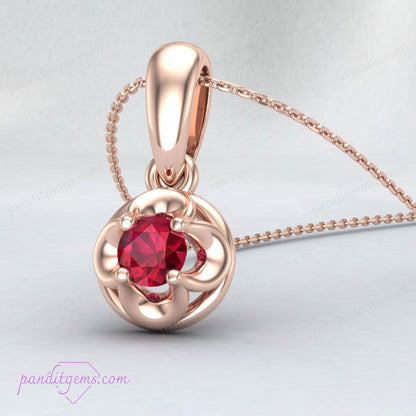 The 18K Gold Filled Ruby Solitaire Necklace displayed elegantly on a jewelry stand.