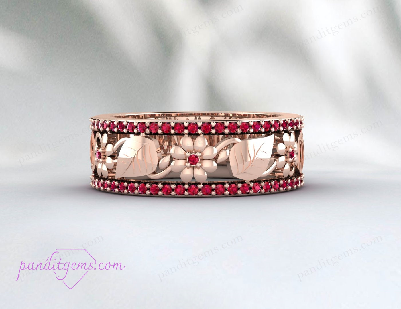 A close-up of the vibrant ruby gemstone set in the rose gold leaf wedding band.
