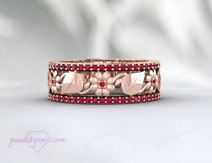 A close-up of the vibrant ruby gemstone set in the rose gold leaf wedding band.