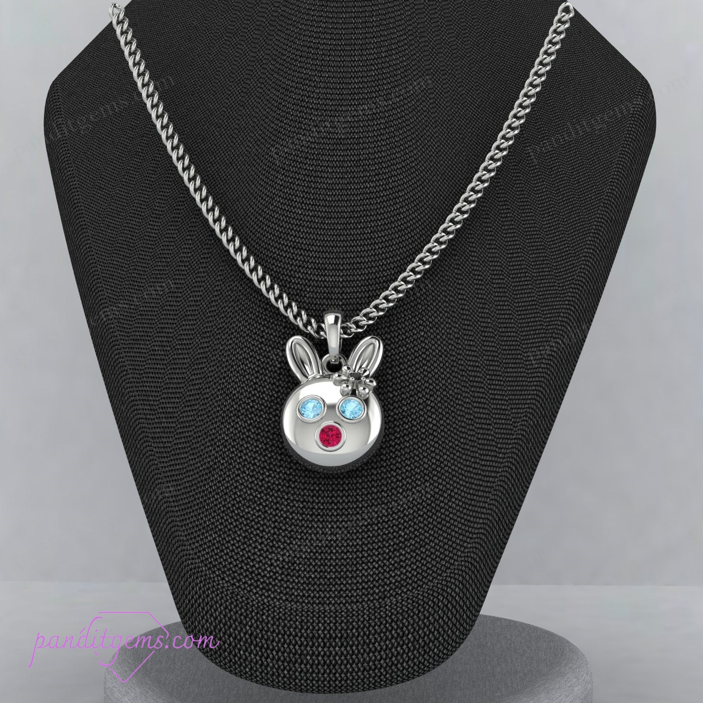 Sterling silver rabbit necklace with Aquamarine, Ruby, and Onyx stones, symbolizing luck and fortune.