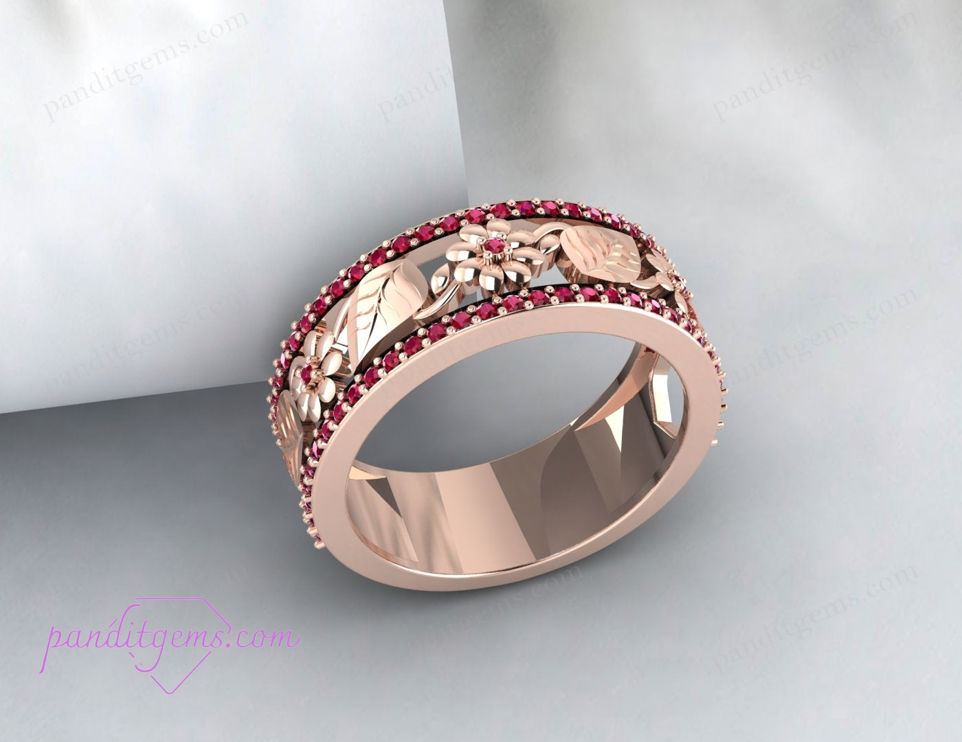 A top view of the wedding band revealing the full floral and leaf design with the ruby in the center.