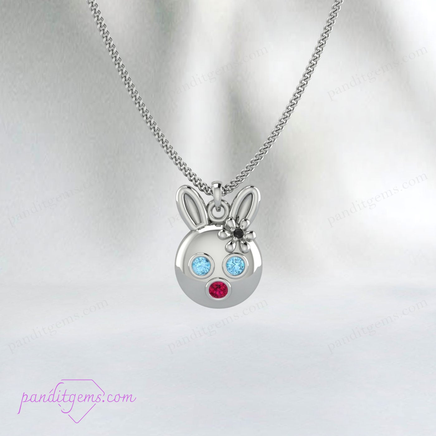 Whimsical bunny charm necklace featuring Aquamarine, Ruby, and Onyx, in sterling silver with gold accents.